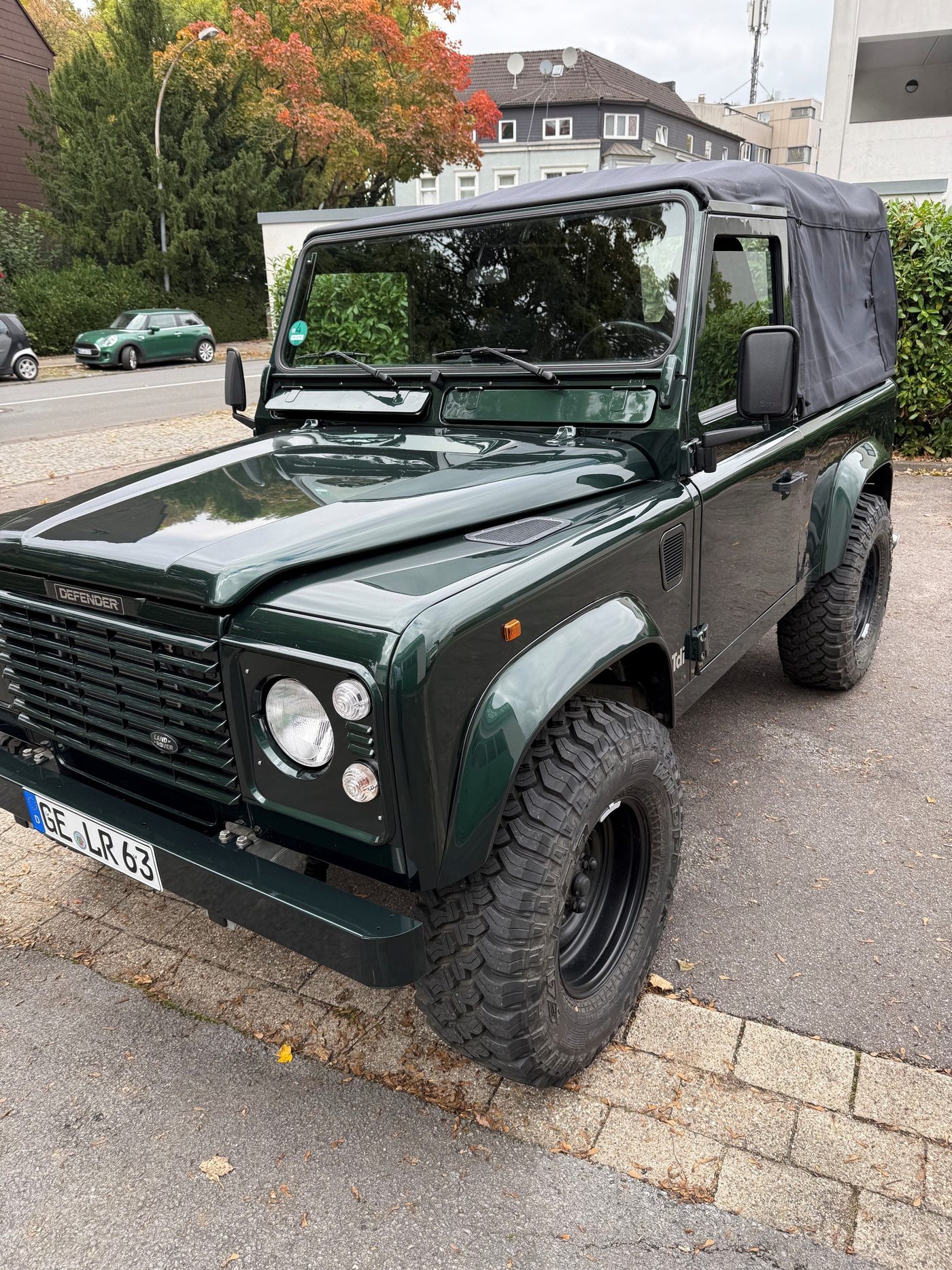 Grüner Land Rover Defender mit Stoffverdeck
