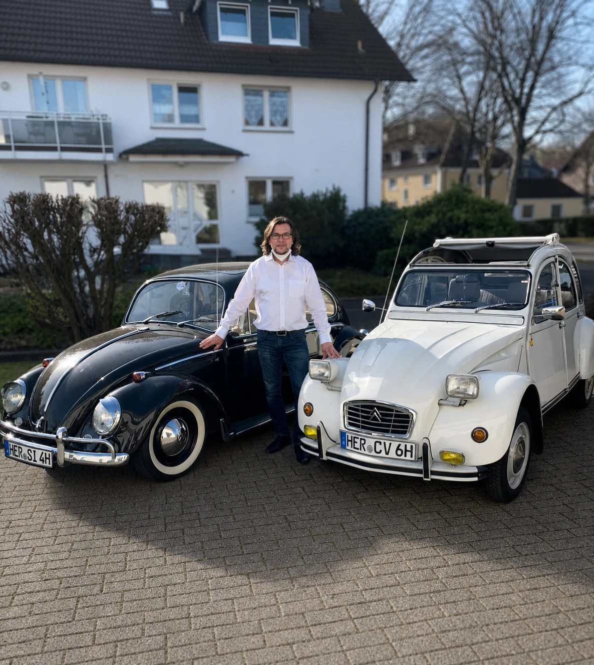 Christian Mastria zwischen einem schwarzen VW Käfer und einer weißen Citroën 2CV